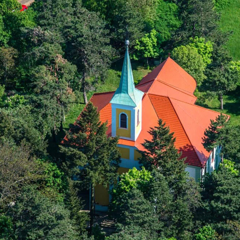 cintorín čaka kostol v korunách stromov
